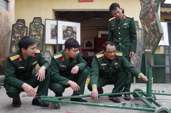 Thượng tá Trịnh Văn Toản (ngồi thứ nhất, bên phải) hướng dẫn cách liên kết và sử dụng máy vận động bia phục vụ huấn luyện.